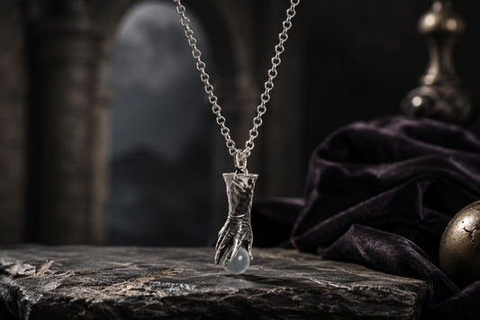 Licensed To Charm Labyrinth Goblin King Crystal Ball necklace featuring a sculpted silver hand holding a pale crystal-style sphere.