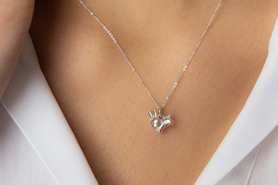 Model wearing a sterling silver Miffy rabbit pendant necklace from Licensed To Charm, handmade and inspired by characters we love.