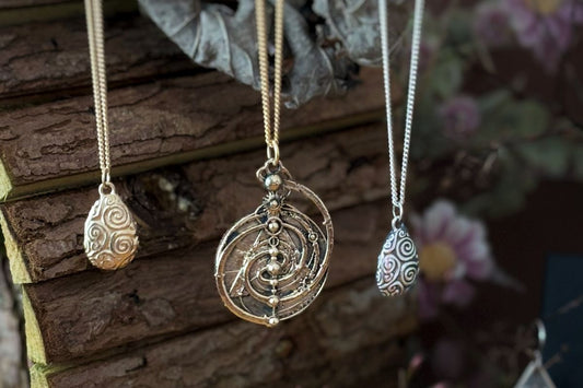 Officially licensed Dark Crystal handmade jewellery necklaces displayed on a rustic woodland background, inspired by Jim Henson’s fantasy film.