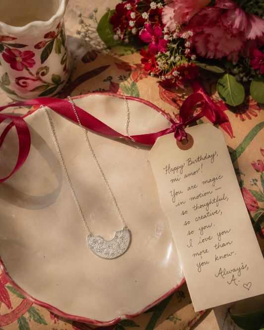 Frida Kahlo Creole Necklace in sterling silver styled as a meaningful jewellery gift with flowers and a handwritten note.