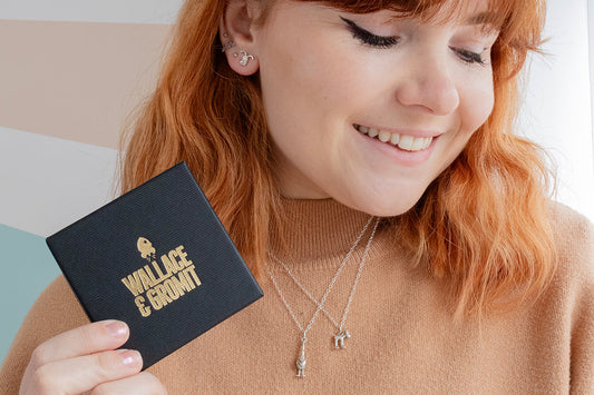 Woman holding Licensed To Charm Wallace & Gromit jewellery gift box with sterling silver necklace – perfect gift for her.