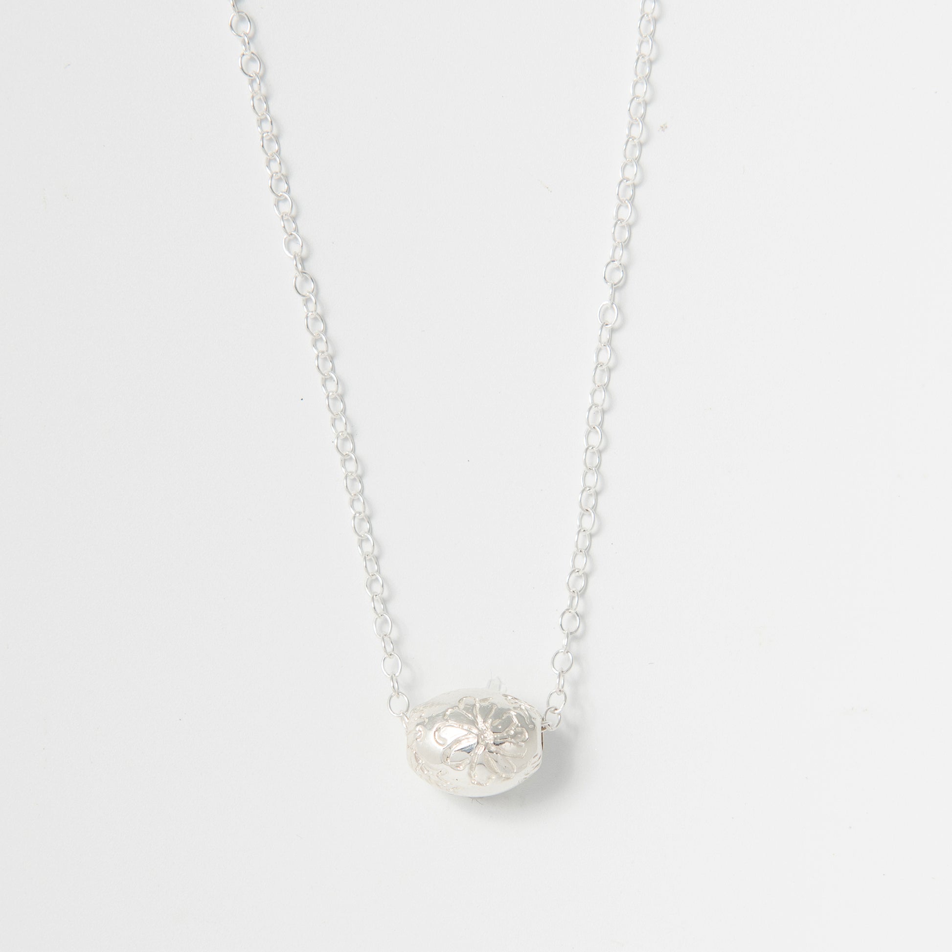 Frida Kahlo Marigold Bead Necklace in sterling silver, featuring an engraved marigold bead inspired by Casa Azul.