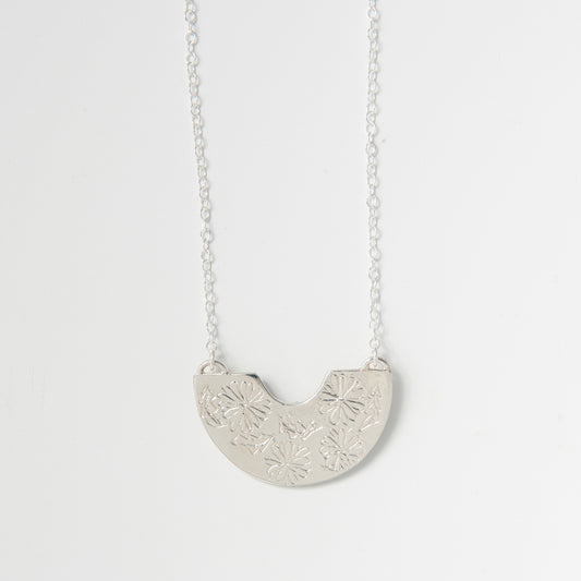 Sterling silver Frida Kahlo Creole Necklace featuring engraved marigold semi-circle pendant on a delicate chain.