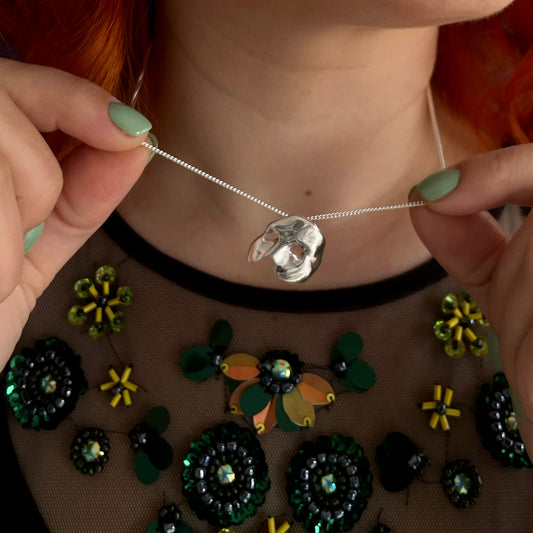 Licensed To Charm Model wearing large Phantom mask necklace with elegant outfit, theatre-inspired styling