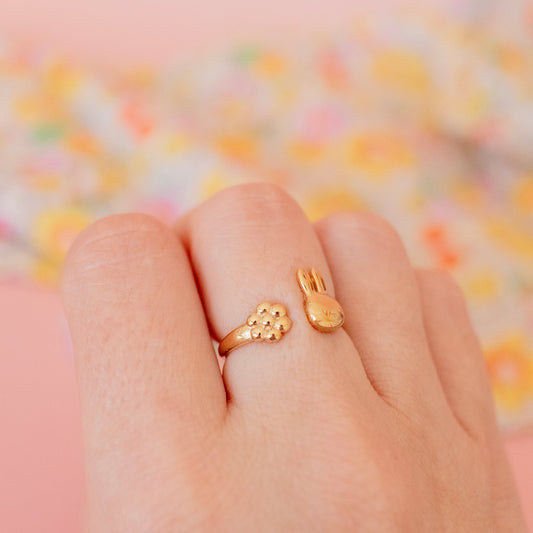Miffy gold vermeil daisy ring – officially licensed Miffy jewellery, handmade in the UK, adjustable ring gift for collectors and fans worn on model with a floral background.