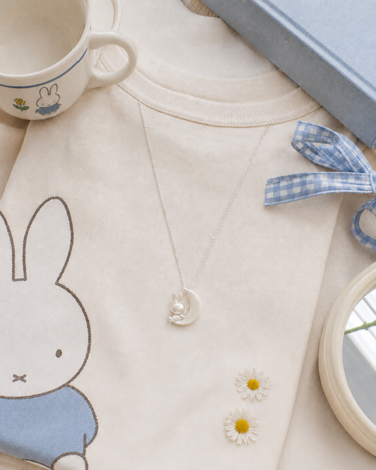 Licensed To Charm officially licensed Miffy sterling silver jewellery styled on a soft neutral outfit in a playful lifestyle setting.