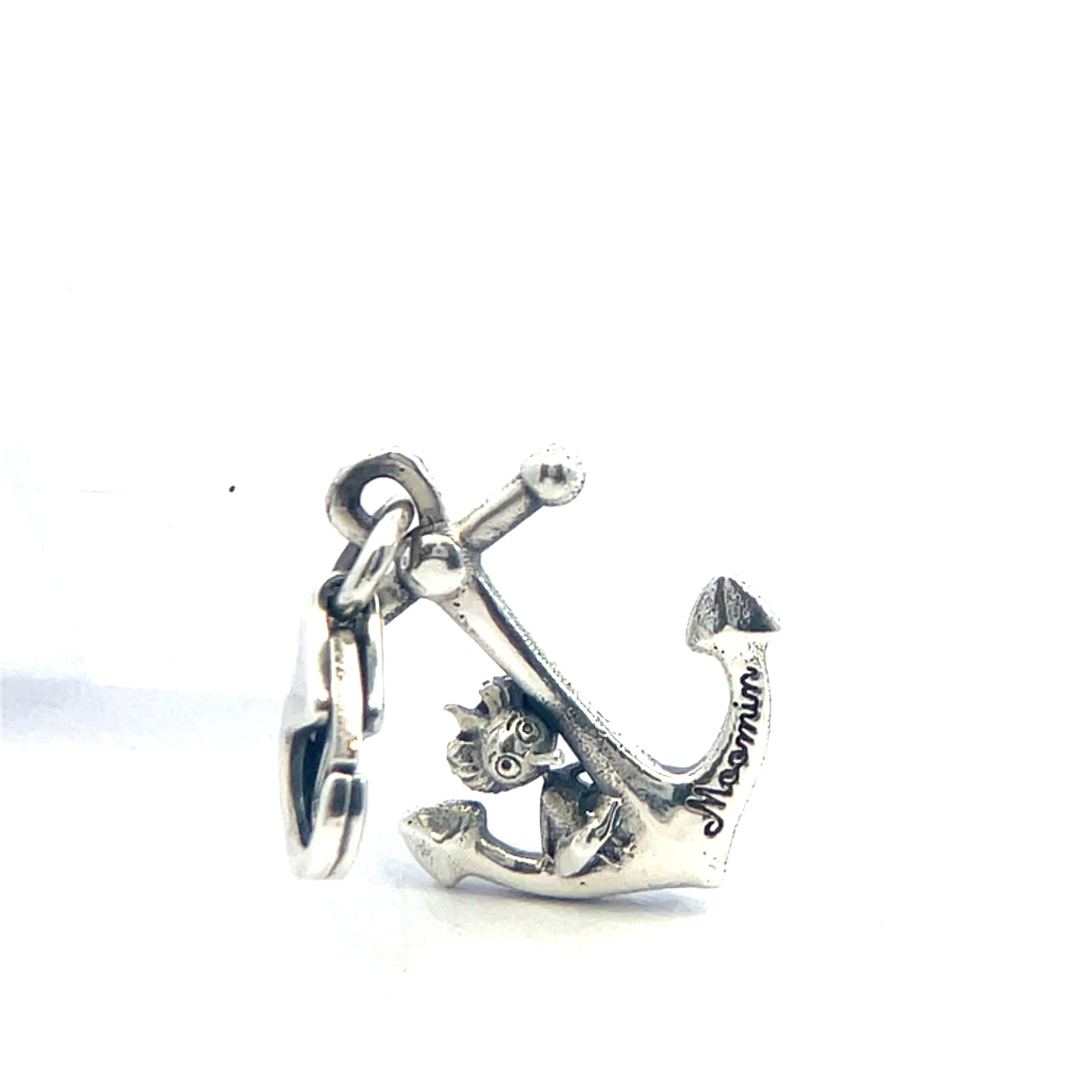 Flat lay of Thingumy & Bob Anchor Charm with polished silver finish, photographed alongside other Moomin jewellery pieces