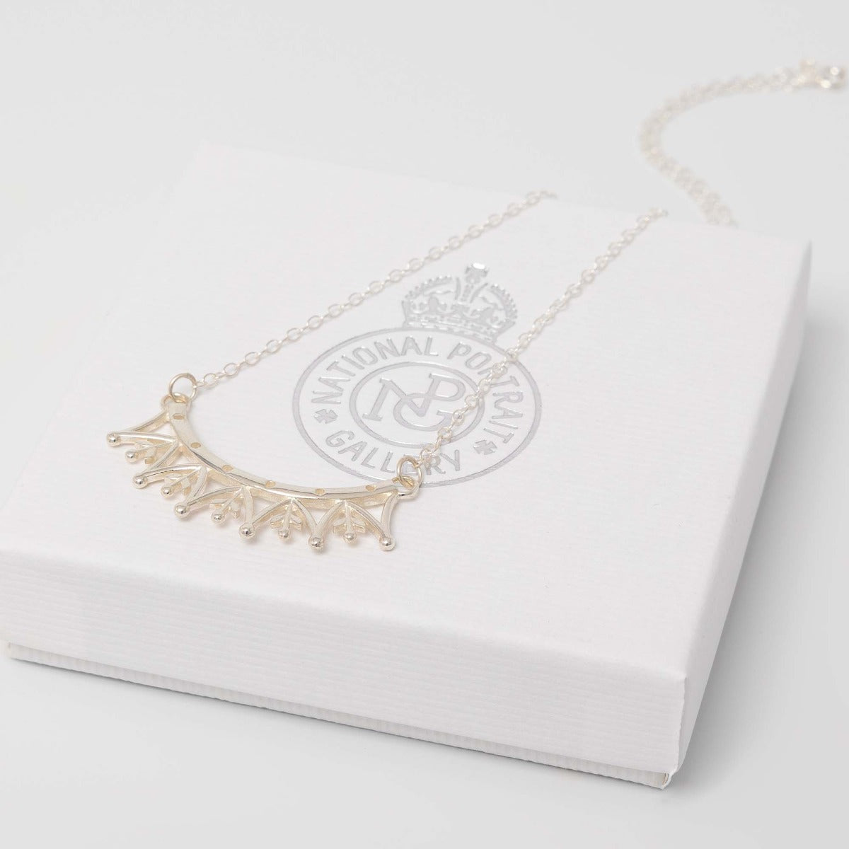 Front-facing view of the Jubilee Crown Necklace in sterling silver, featuring a delicate crown-shaped pendant on a short chain