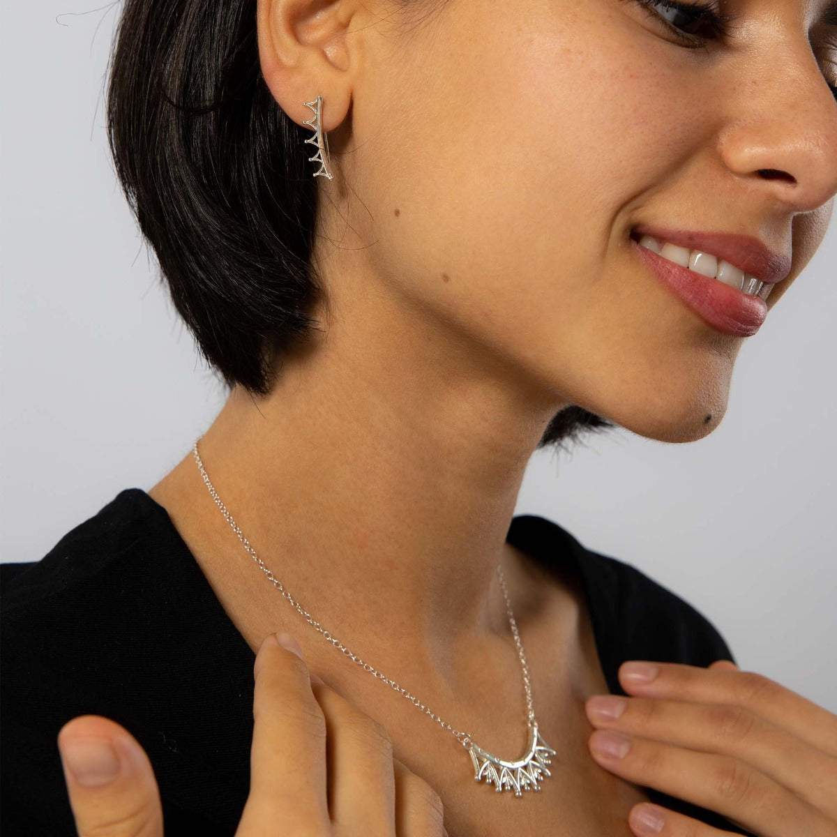 Jubilee Crown Necklace styled on a model, worn just below the collarbone, paired with other silver jewellery for a regal everyday look.