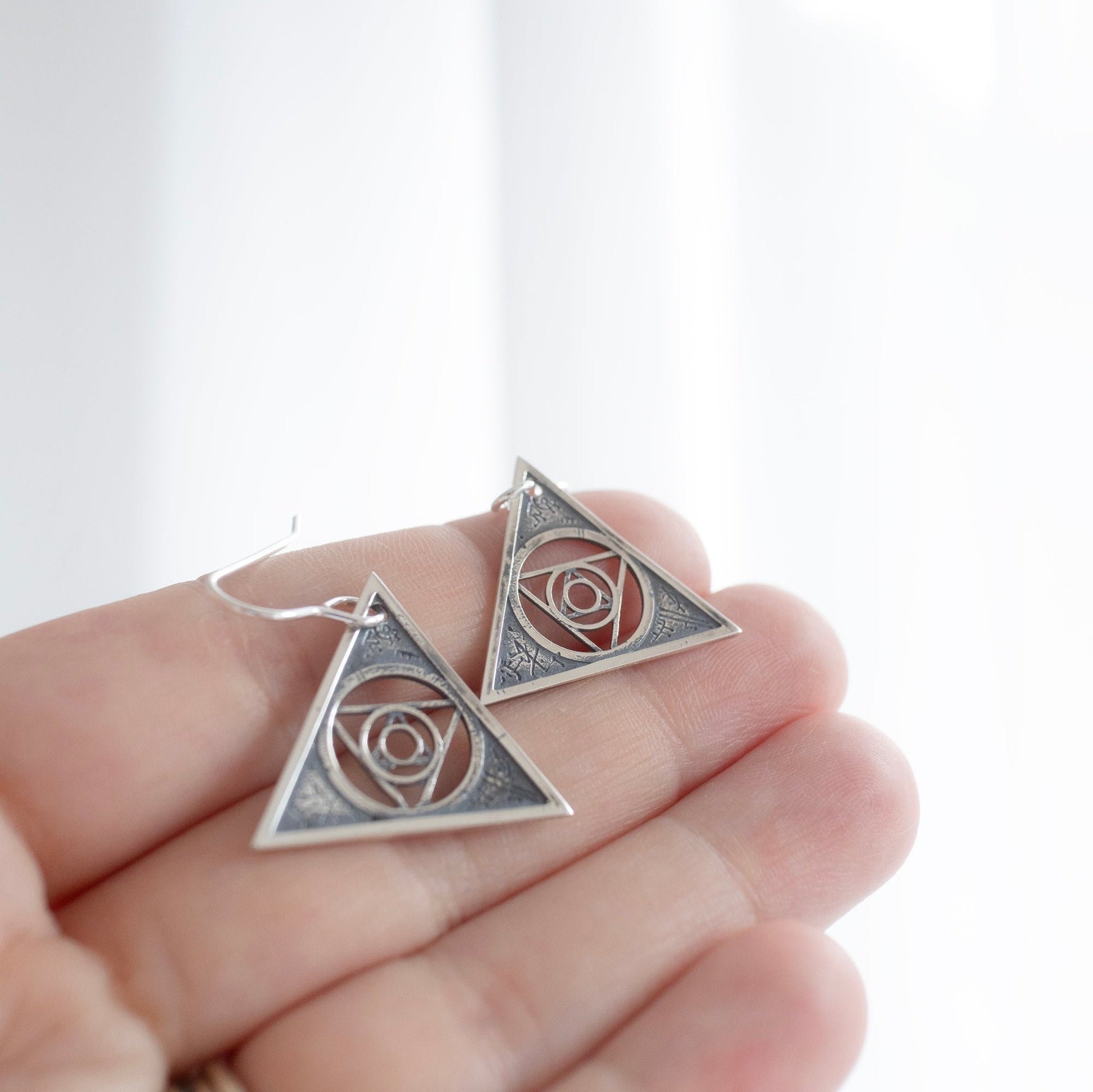 Handcrafted sterling silver Aughra's Triangle Earrings, featuring a geometric design with the Eye of the superimposed suns. Inspired by Jim Henson’s The Dark Crystal, perfect for lovers of mystical and Gothic jewellery