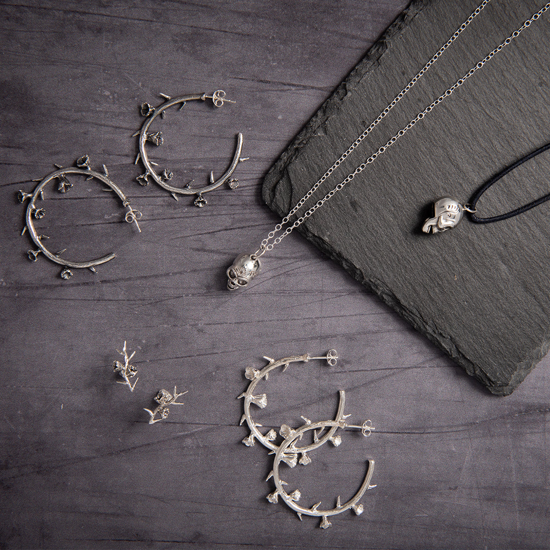 Editorial-style image of collection of the the Thorn Hoop Earrings with  and dramatic background emphasisng their statement allure.