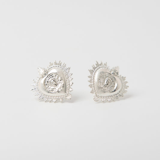 Front-facing view of the Frida Kahlo Viva La Vida Heart Earrings in sterling silver, featuring Frida’s face within a sacred heart design surrounded by flowers and a bird.