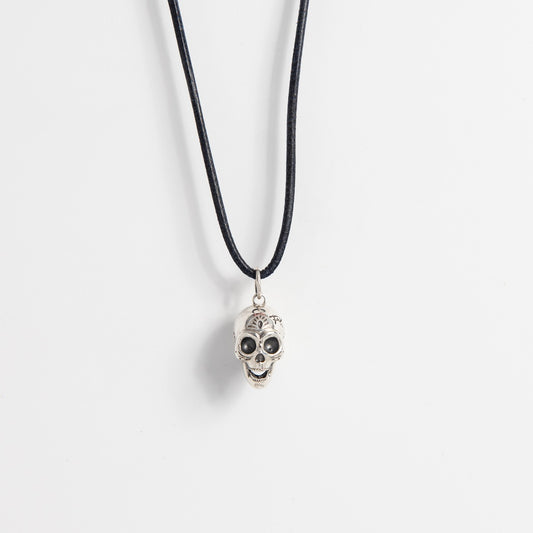 Front-facing view of the Frida Kahlo Sugar Skull Necklace in sterling silver, featuring a detailed Calavera skull pendant on a black leather necklet.