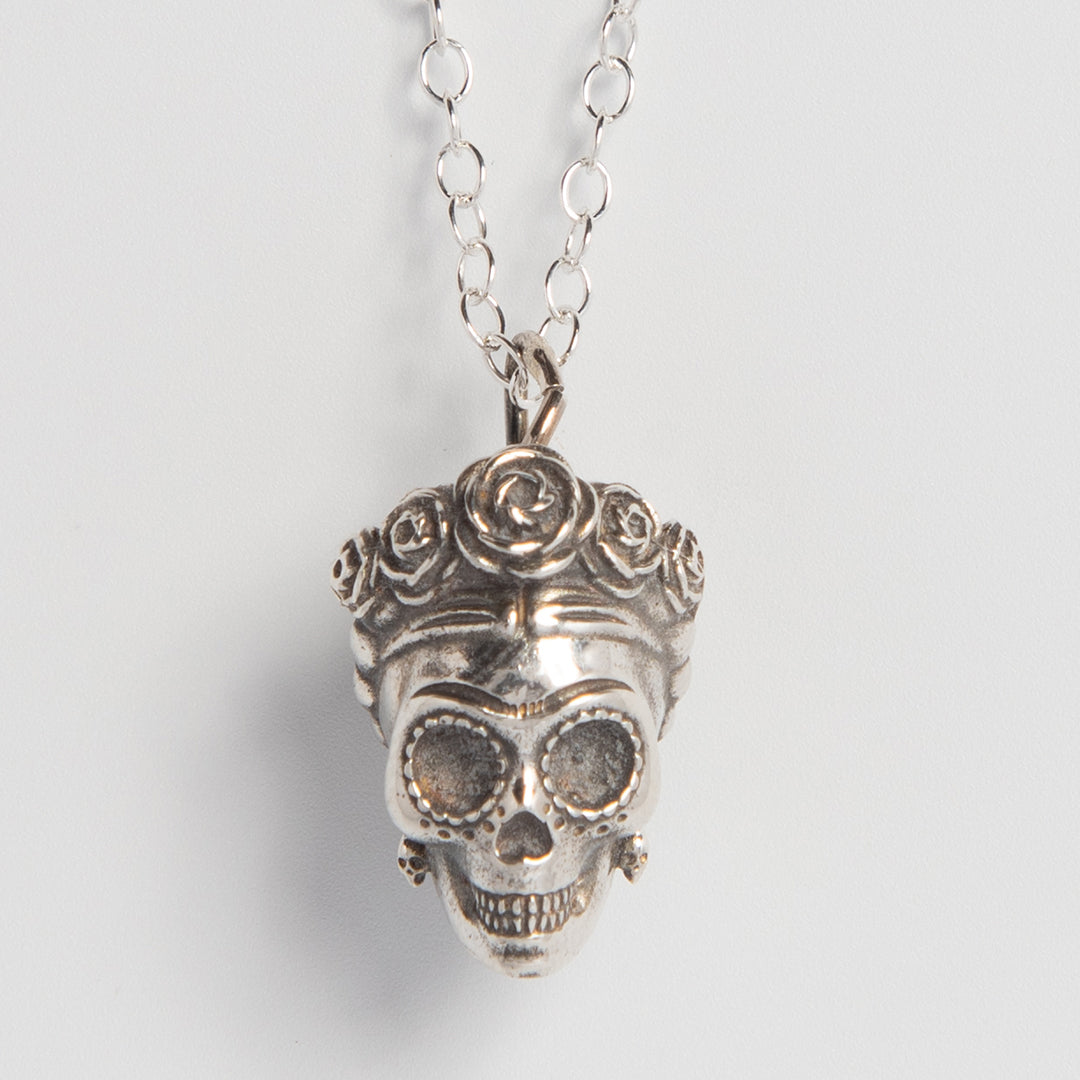 Close-up of the sterling silver Sugar Skull pendant, highlighting the intricate detailing of Frida Kahlo’s floral crown and stylised facial features.