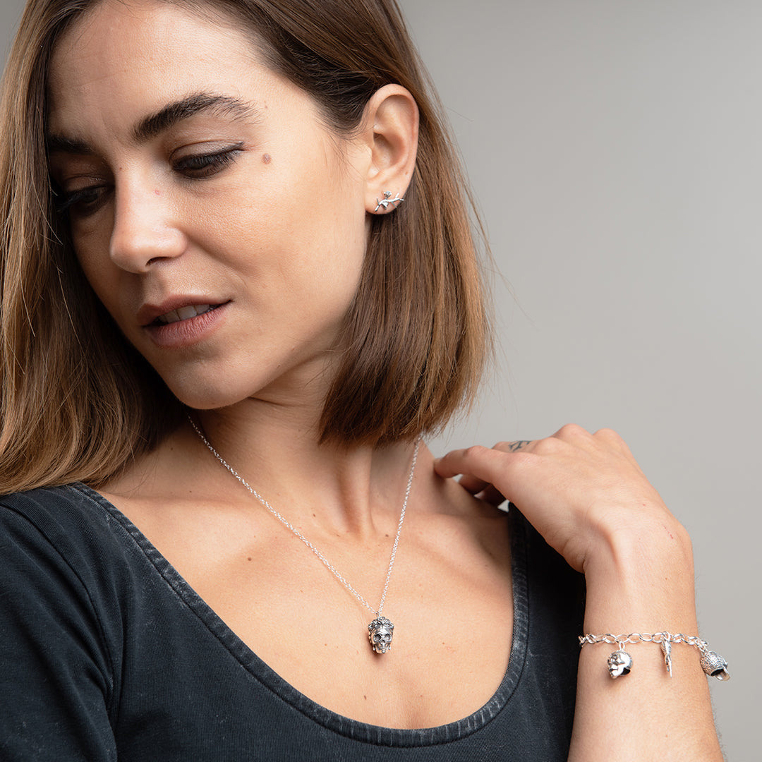 Model layering the Frida Kahlo Sugar Skull Necklace with other chains, showcasing its versatility and statement appeal