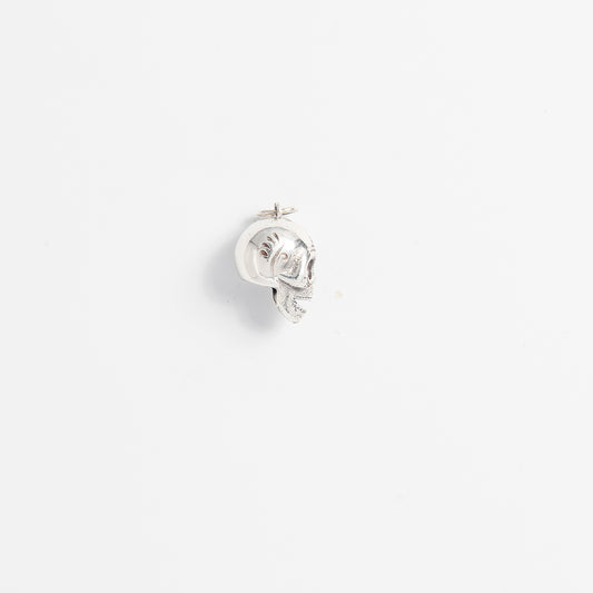 Close-up of handcrafted sterling silver skull charm with sculpted facial features and artisan texture.