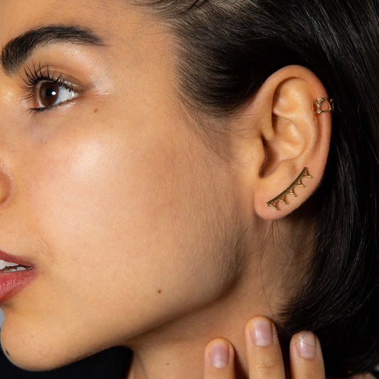 Model wearing the 18ct gold vermeil Jubilee Crown Ear Cuffs, styled with additional earrings for a layered look inspired by royal elegance.