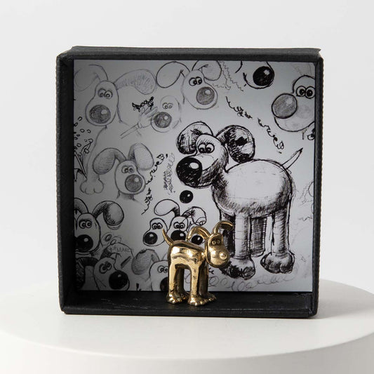 Gromit bronze miniature figurine displayed with Wallace & Gromit scene artwork, a collectable gift for fans.