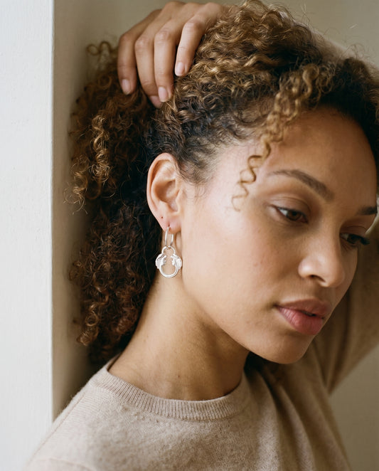 Jesus Christ Superstar silver plated hoop earrings worn on model, a musical theatre gift for Andrew Lloyd Webber fans.