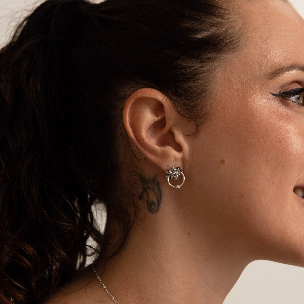 Close-up of one Labyrinth Door Knocker Earring on model’s ear, highlighting the detailed sculpting and signature movable ring.