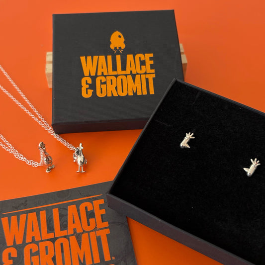 Licensed To Charm Feathers McGraw Earrings from our Wallace & Gromit collection with Feather's necklace on an orange background