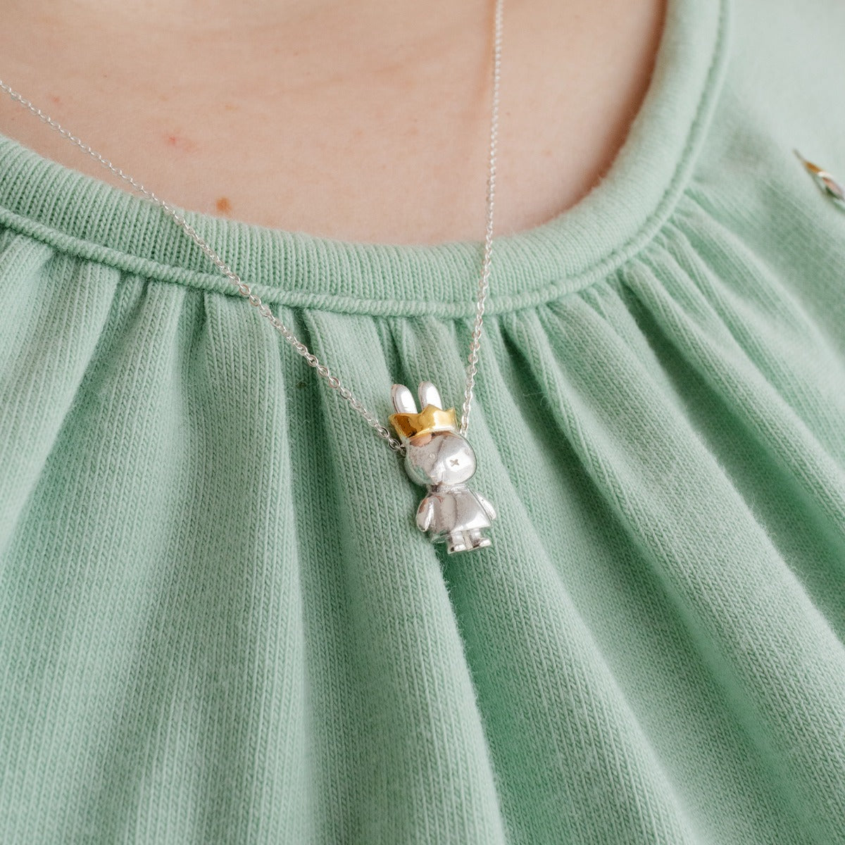 Close-up of Queen Miffy pendant showing gold crown and gown detailing on sterling silver Miffy face.