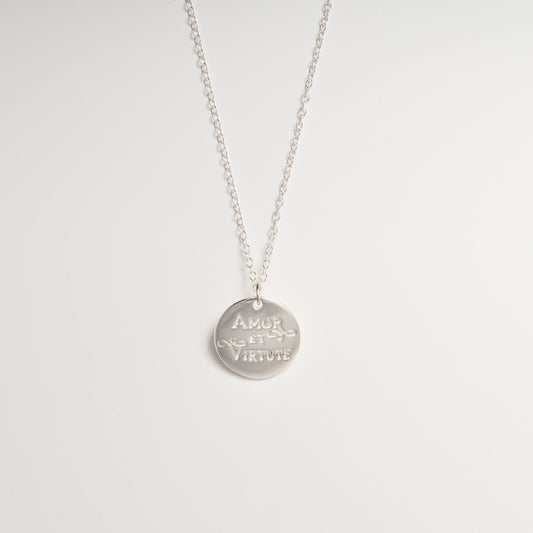 Close-up of the Amor et Virtute Necklace pendant, highlighting the polished sterling silver finish and detailed engraving.