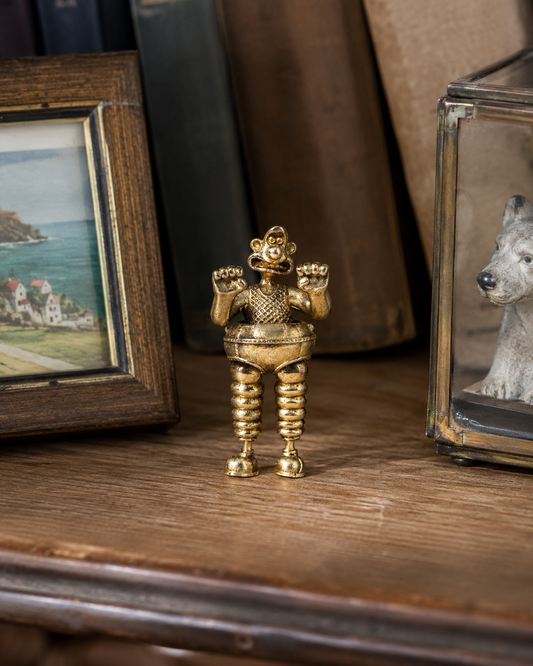Wallace & Gromit Wrong Trousers miniature bronze figurine displayed on a collector shelf with books and small keepsakes