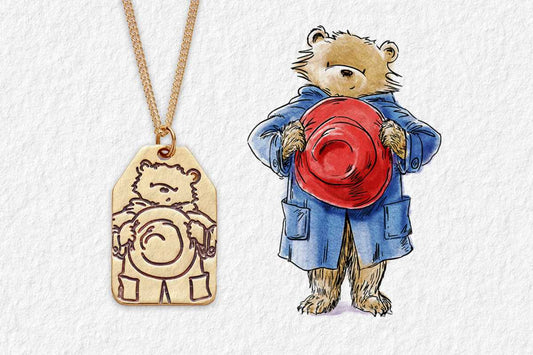 Paddington Bear necklace made from 18ct Gold Vermeil with the character inspiration beside him 
