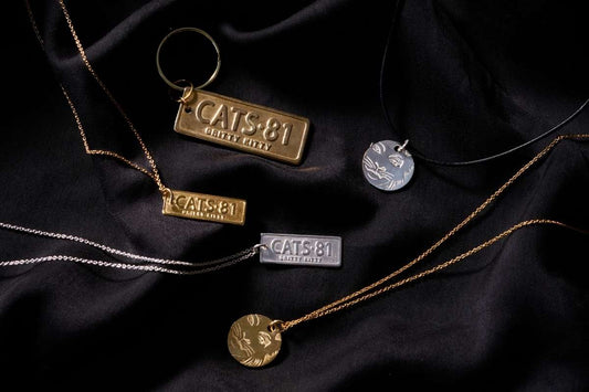 CATS jewellery collection by Licensed To Charm with CATS 81 necklaces, keyring and Rum Tum Tugger jewellery on black fabric
