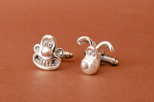 Wallace and Gromit sterling silver cufflinks on a brown background, officially licensed Aardman jewellery