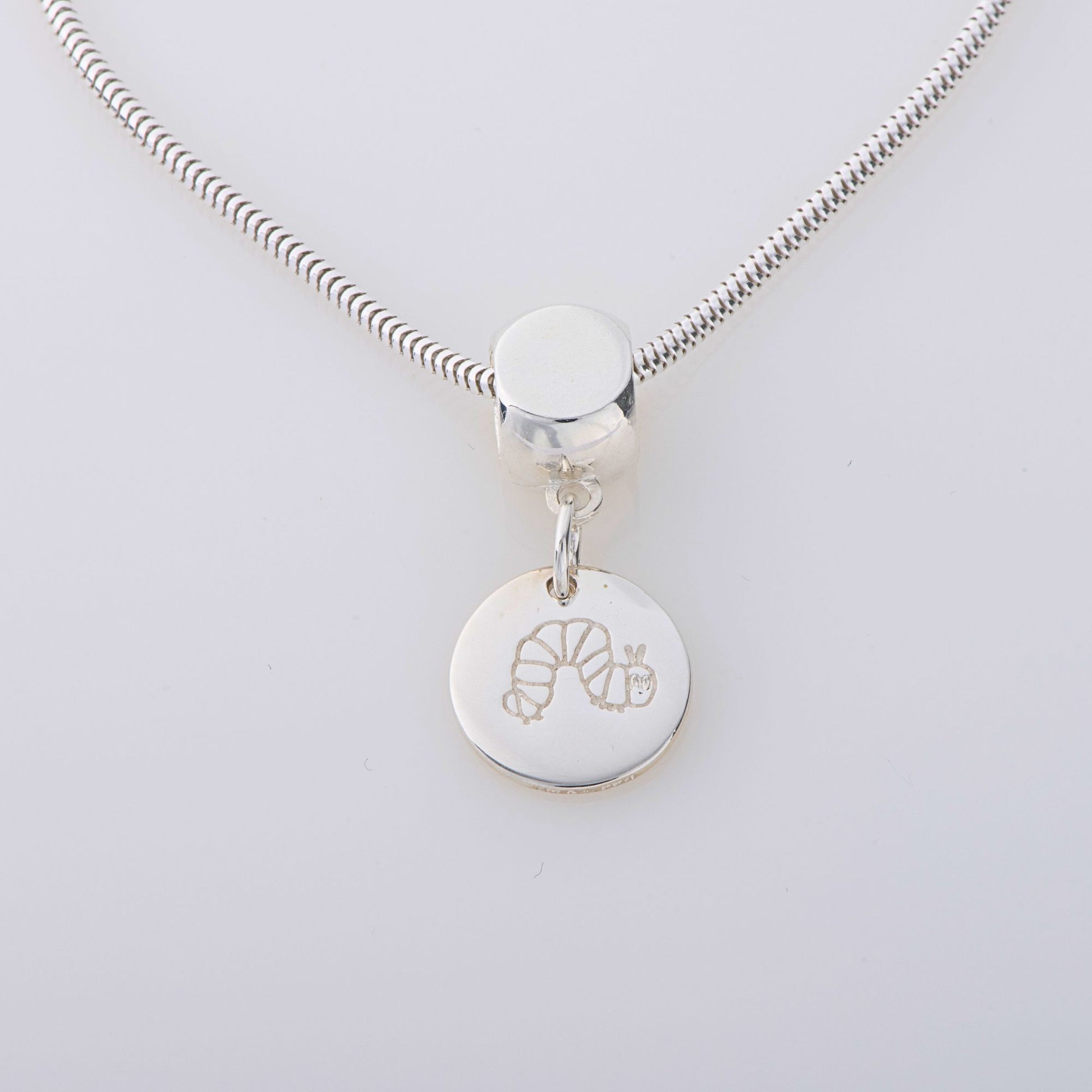 Blackbird Jewellery Handmade Very Hungry Caterpillar Disc Dangle Necklace in sterling silver, featuring an etched design of Eric Carle’s iconic caterpillar. A whimsical jewellery gift for all ages.