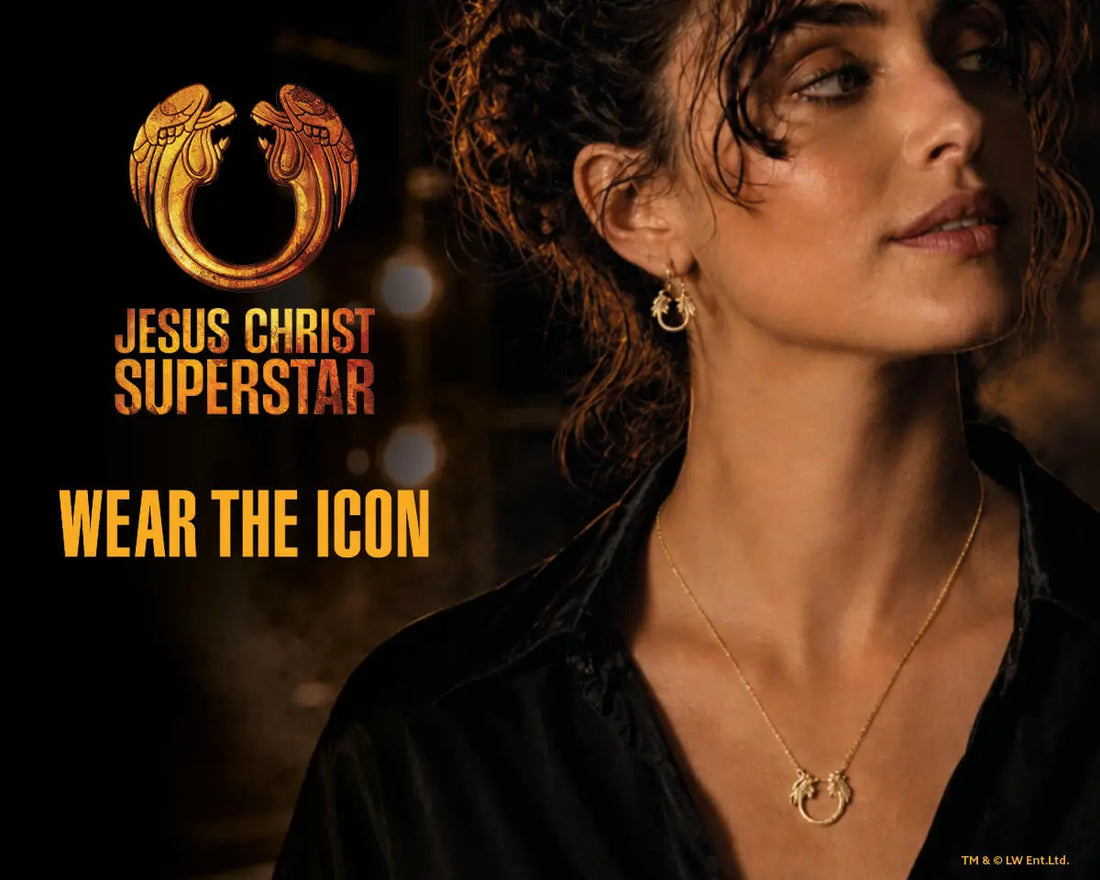 Jesus Christ Superstar gold jewellery collection banner featuring a model wearing the pendant necklace and hoop earrings, with the show’s iconic emblem in a dramatic theatre-inspired setting.