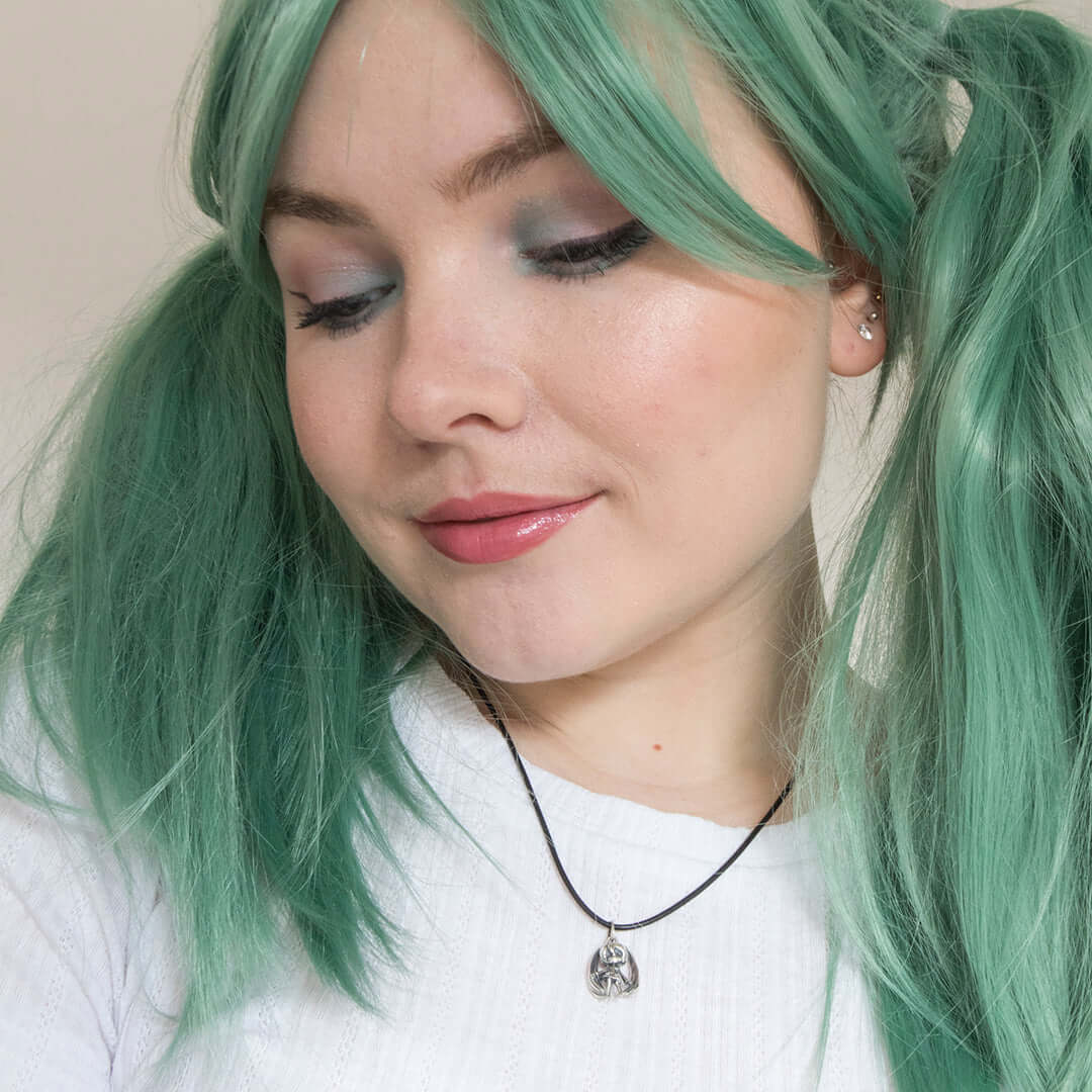 Model wearing polished silver Hatsune Miku necklace with black leather necklet for a stylish anime fan look.