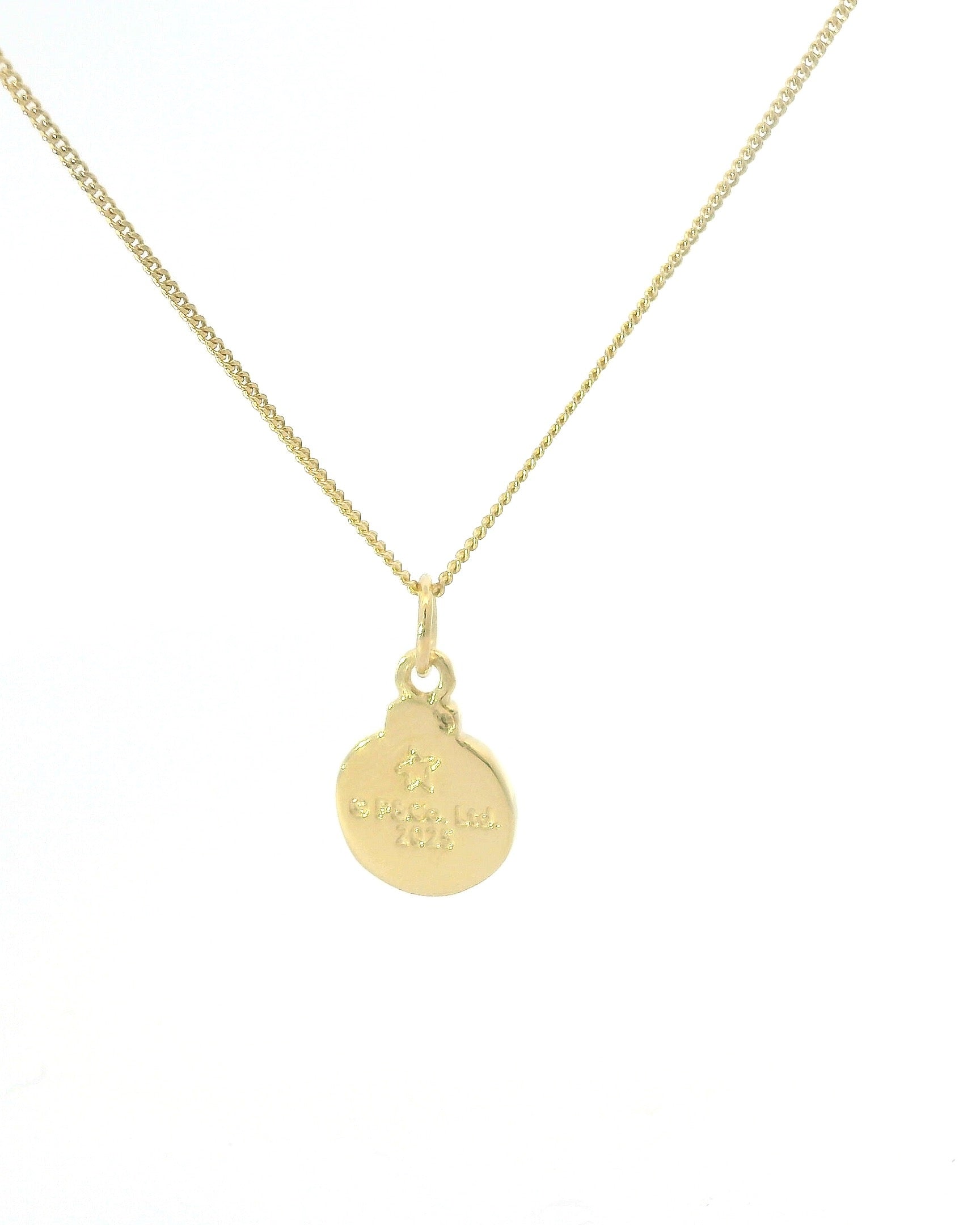 Licensed To Charm Close-up showing Paddington pawprint engraved onto mini bauble pendant in 18ct Gold Vermeil.