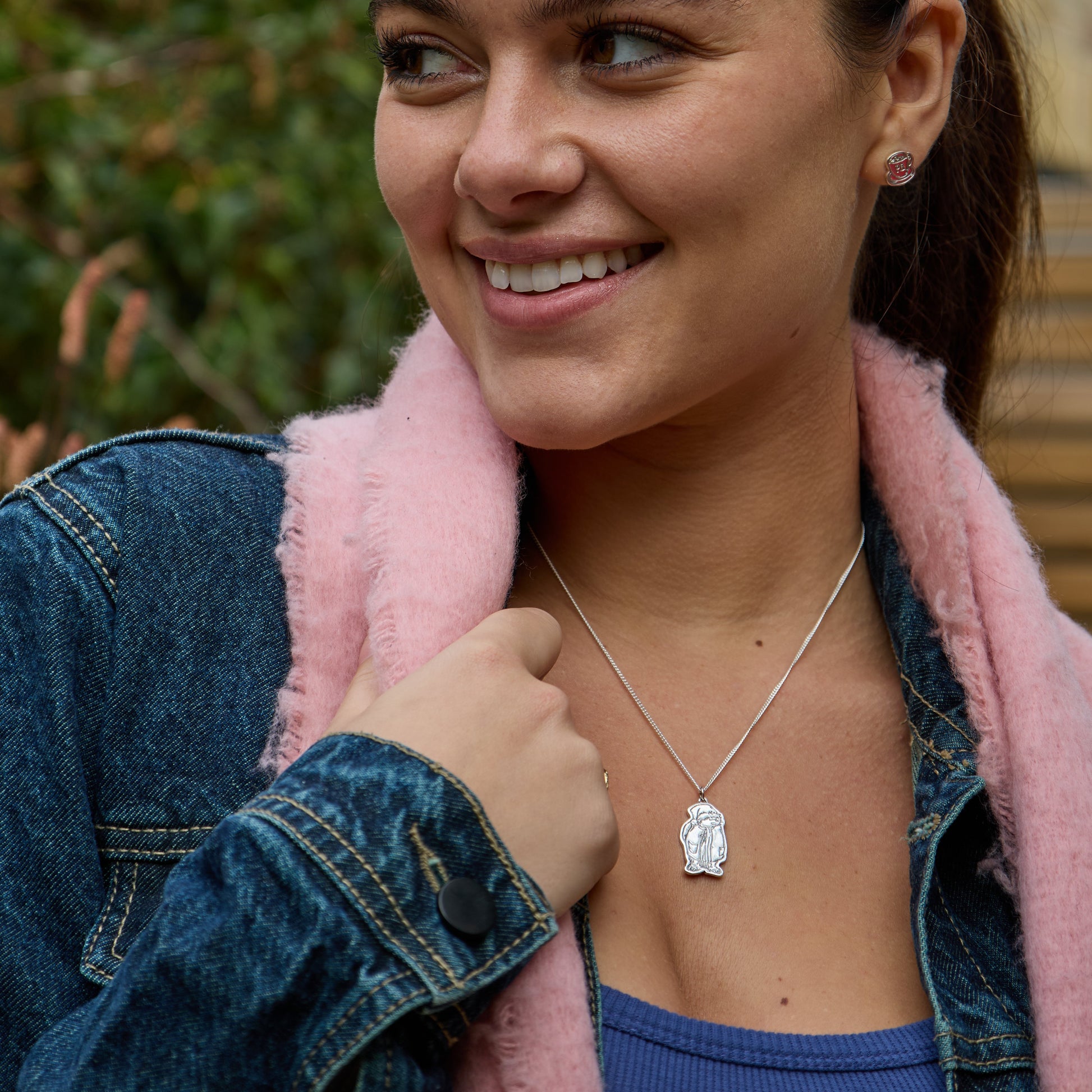 Licensed to Charm sterling silver Paddington pendant with Santa hat shown worn close up with denim jacket, ideal Christmas gift jewellery.