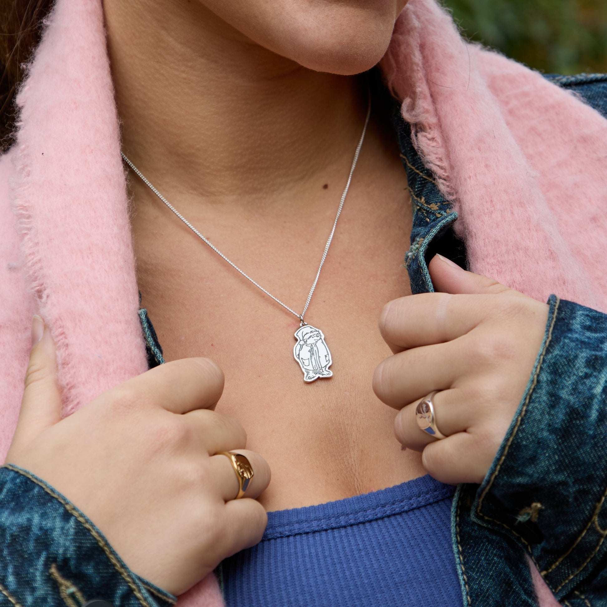 Licensed to Charm sterling silver Paddington necklace with Santa hat worn by a smiling model outdoors, festive jewellery for Christmas gifting.