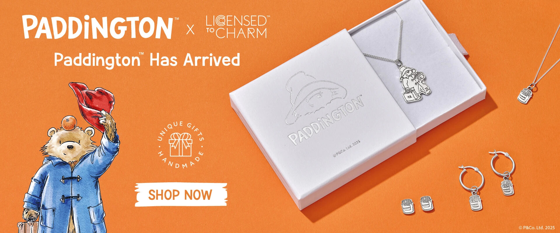 Licensed To Charm official Paddington™ jewellery launch banner featuring sterling silver necklace, marmalade jar hoop earrings and studs on orange background with Paddington illustration