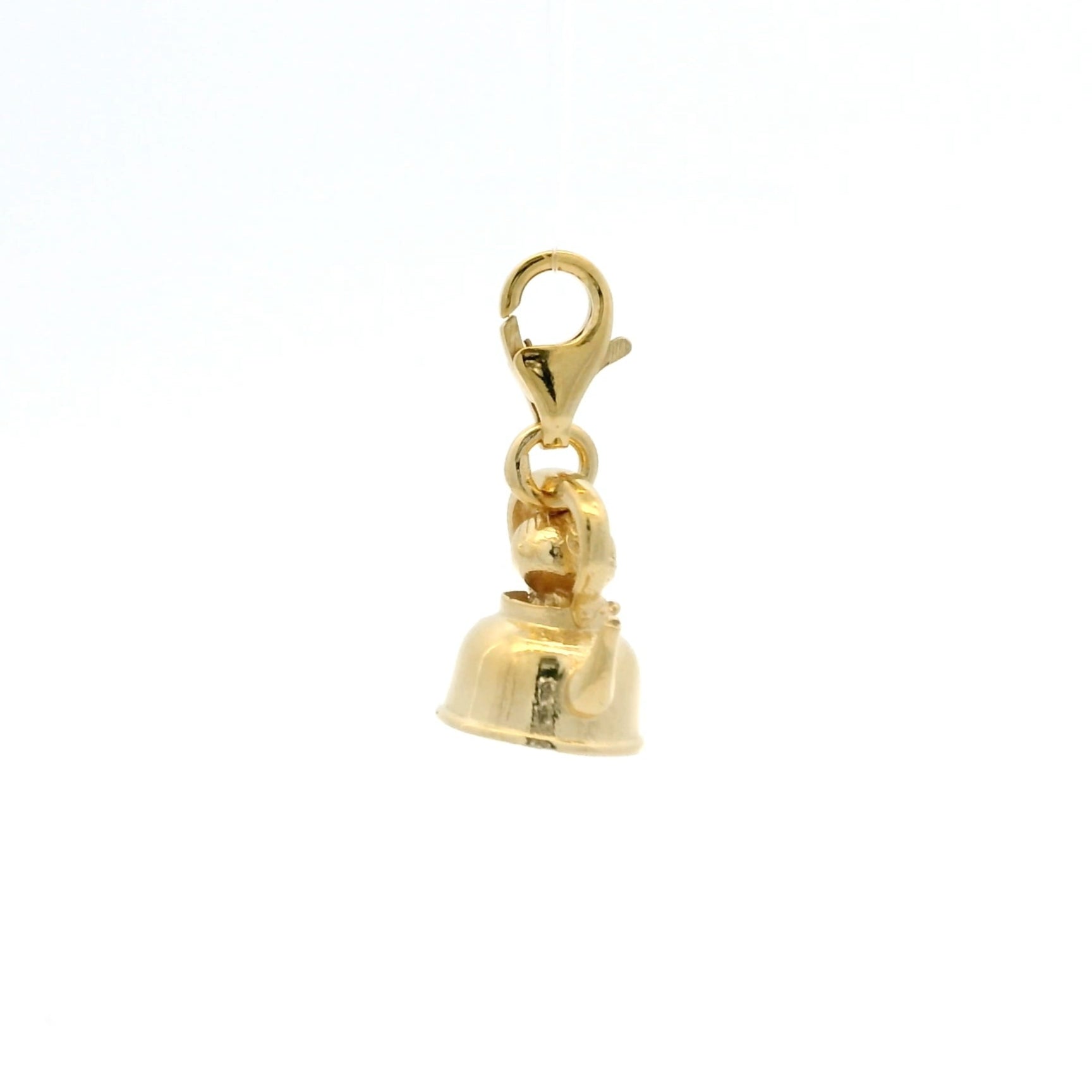 Flatlay of gold Little My charm in a teapot with clip-on clasp, highlighting handcrafted texture and warm gold finish