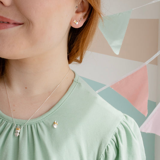 Close-up of Queen Miffy earrings featuring her iconic face and gold-plated crown.