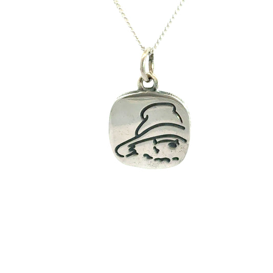 Sterling silver necklace featuring a square pendant with etched Paddington Bear face on a white background
