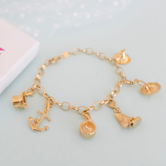 Gold vermeil Nibling in Umbrella charm displayed flat on a plain surface, capturing the elegant lines and rich finish.