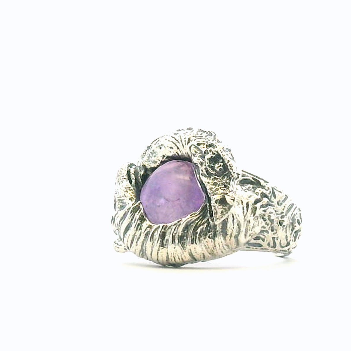 Side angle of the Skeksis Ring showing detailed swirling silver patterns and the raised amethyst setting.