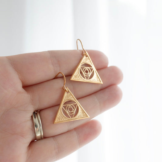 Gold Vermeil Aughra's Triangle Earrings, handcrafted with a mystical triangle design and the Eye of the superimposed suns, capturing the cosmic lore of The Dark Crystal. Elegant and meaningful for collectors and fans