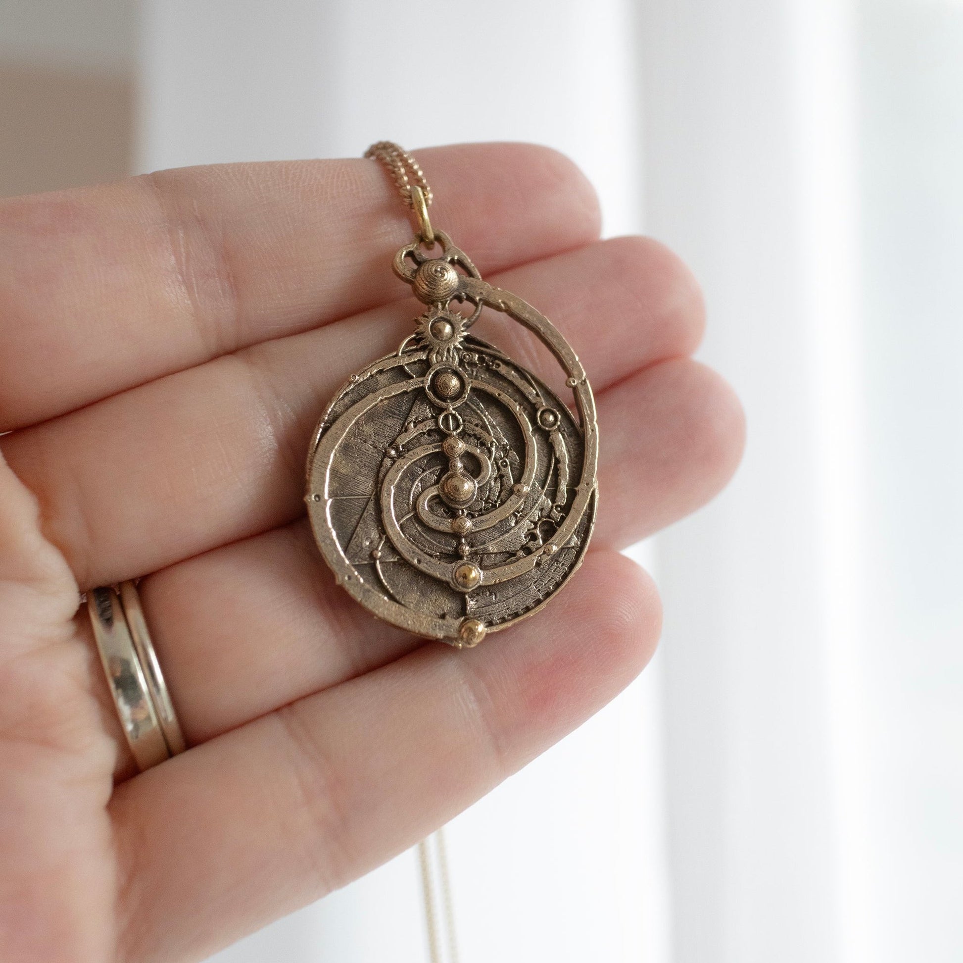 Brass Mystic Spiral Necklace, a faithful replica of the Master Time Spiral from The Dark Crystal. Features symbolic spirals and triangle design, representing the convergence of time in the film’s mythology. Handmade and nickel-free.