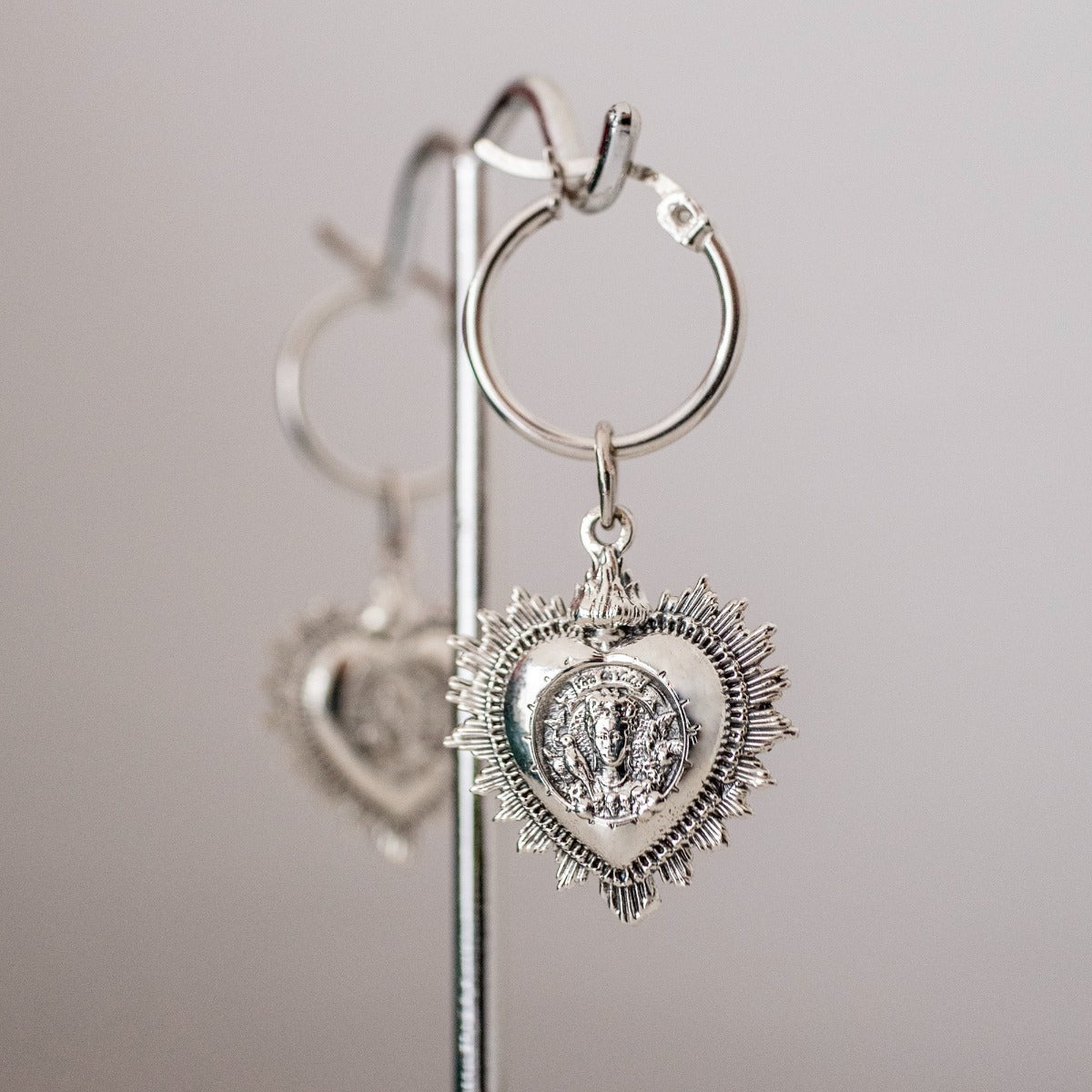 close up of Frida Kahlo heart hoop earrings with floral and bird motifs