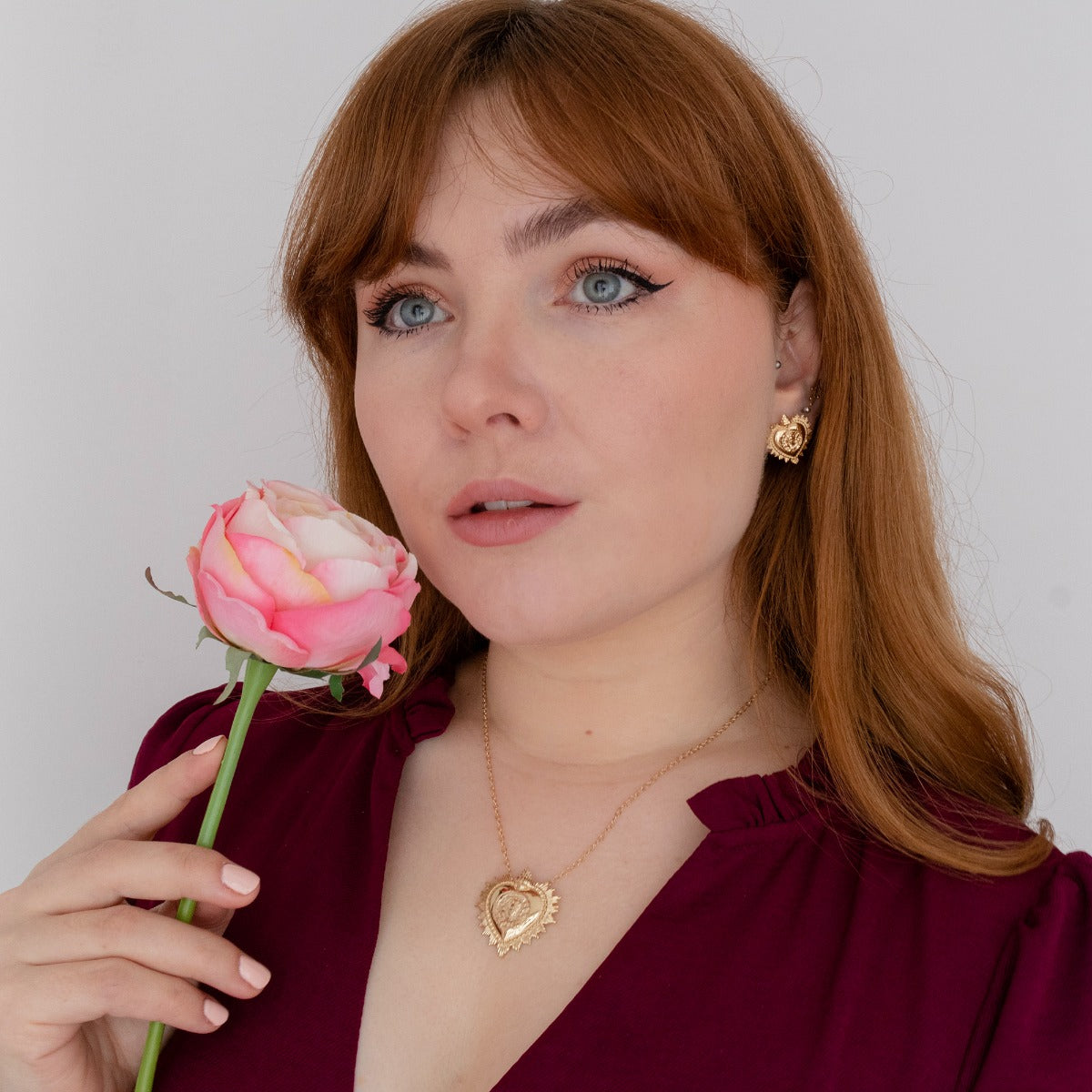 Frida Kahlo heart stud earrings in gold vermeil styled with flowers as a gift