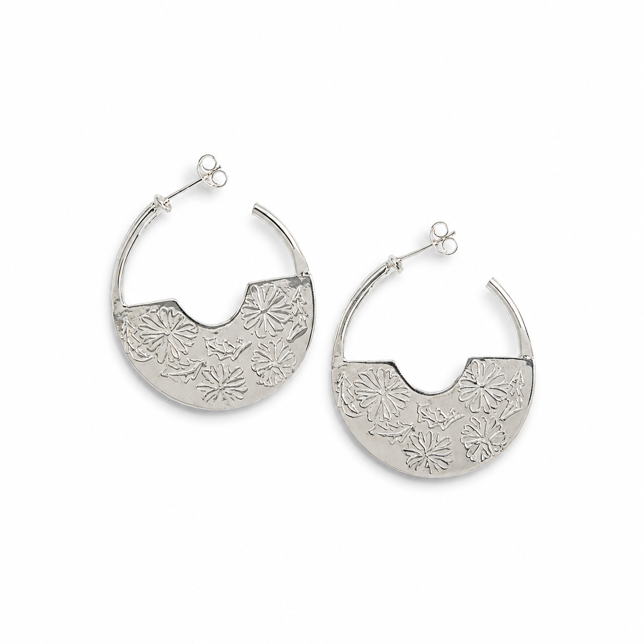 A pair of Frida Kahlo Marigold Creole Hoop Earrings in sterling silver crescent-shaped hoop earrings with a textured floral pattern, displayed on a clean white background.