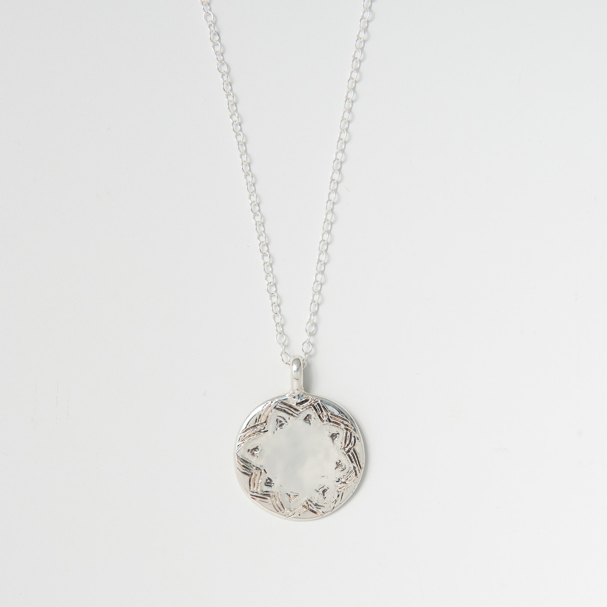 Sterling silver Frida Kahlo disc necklace on white background