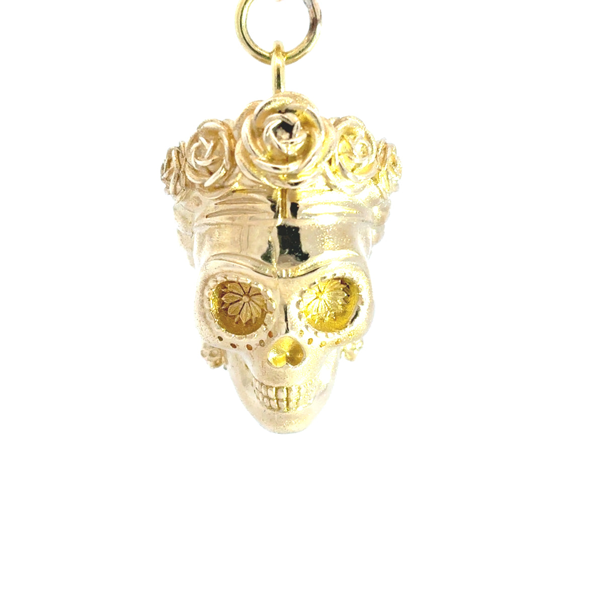 A brass keyring of Frida Kahlo sugar skull  with a floral crown, photographed against a plain white background.